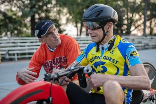 two men discuss matters in a cycling environment