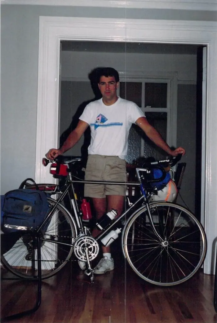 Young man with his packed bicycle ready for adventure